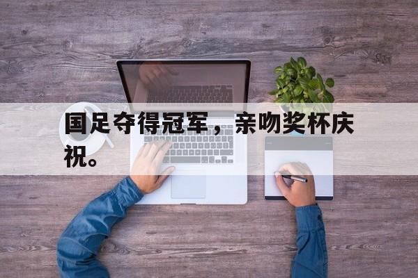 国足夺得冠军，亲吻奖杯庆祝。